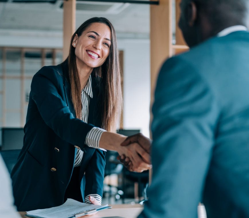 A photograph of a businesswoman shaking hands with a client